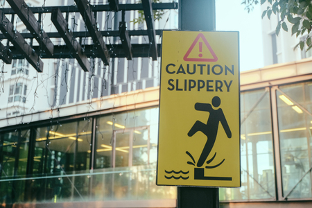 Signage read â€œ CAUTION SLIPPERYâ€ for public attention while standing closed to pool edge