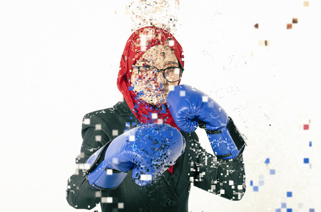 Confident expression, young business woman with boxing glove dispersing into pixels effectの写真素材