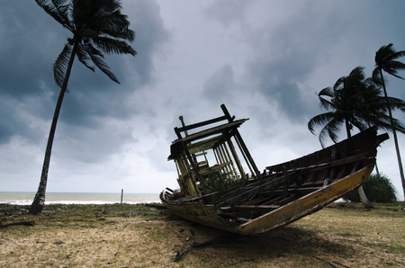 Abandon shipwreck near the sea shore under blue sky background and bright sunの写真素材