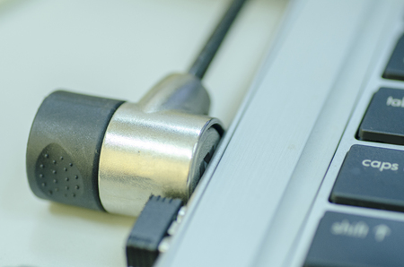 close-up image of laptop locked by cable lock for security conceptの写真素材
