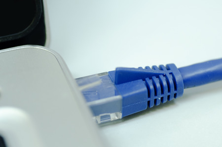 Closeup ethernet cable connected to the Lan port on laptop for computer network conceptの写真素材