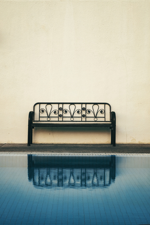 empty benches  with reflection near the swimming pool