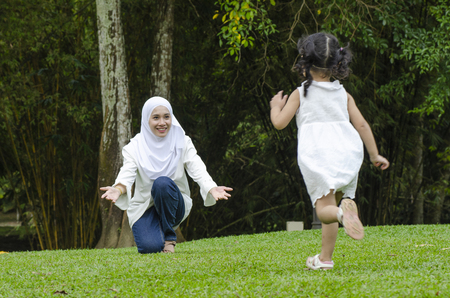 Family happiness concept, young mother  with her daughter having fun at public parkの写真素材