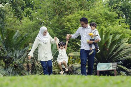happy family concept with enjoying expression face,having fun at public park.の写真素材