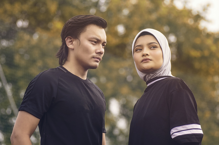 Sport and healthy lifestyle concept. portrait of young sportsman and woman standing over shallow depth of field backgroundの写真素材