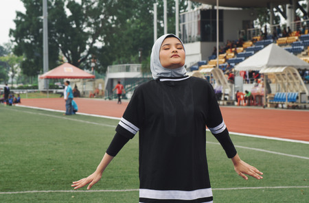 Sport and healthy lifestyle concept. Sportswoman stretching and having some warming up before runningの写真素材