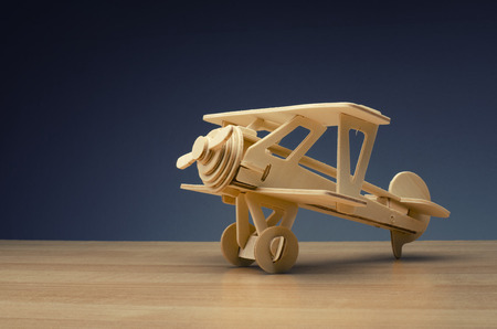 toy wooden retro airplane on wooden table background for travel  conceptの写真素材