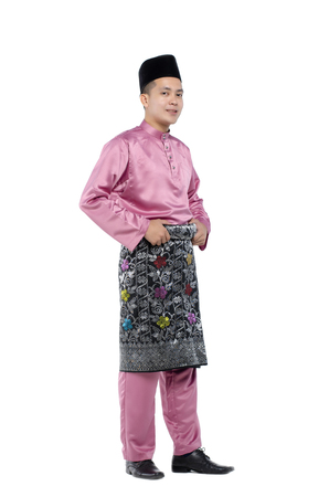 Portrait of young and handsome asian man with traditional clothing during hari raya over white backgroundの写真素材