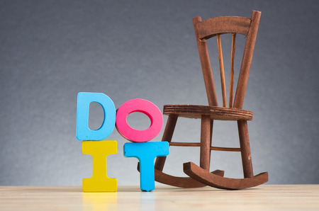 Do and donât concept, colorful alphabet word DO IT on wooden desk over gently lit dark backgroundの写真素材