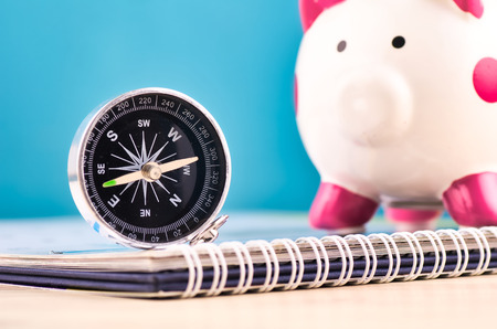 compass on calendar over piggy bank background for future financial direction planning conceptの写真素材