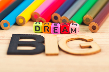 business motivational and inspirational quotes, colorful cubes with words DREAM BIG on wooden deskの写真素材