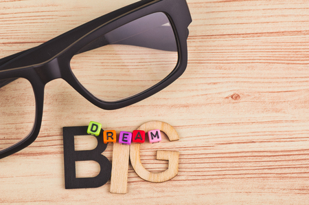 business motivational and inspirational quotes, colorful cubes with words DREAM BIG on wooden deskの写真素材