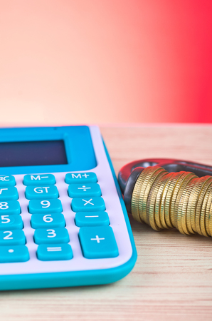 devaluation and financial crisis, calculator and coins squeezed tightly in a G-Clampの写真素材