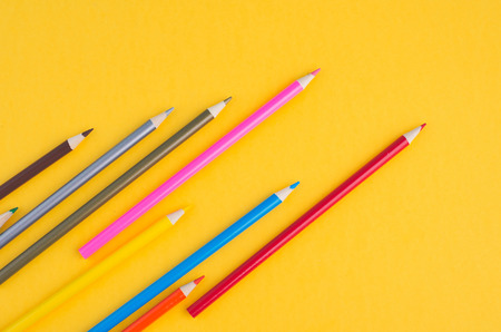 close-up image of Colourful pencils over yellow background