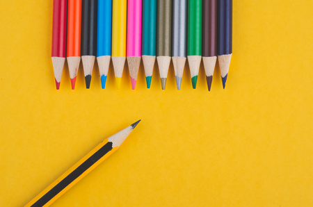 close-up image of Colourful pencils over yellow backgroundの写真素材