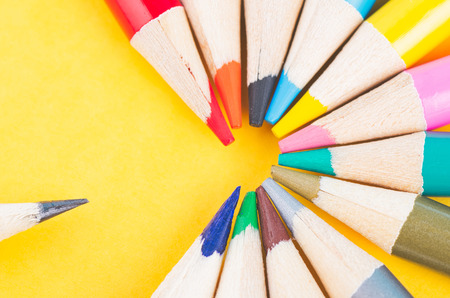close-up image of Colourful pencils over yellow backgroundの写真素材