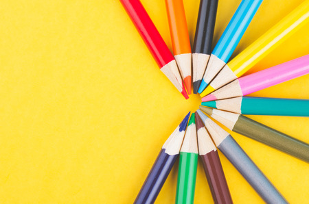 close-up image of Colourful pencils over yellow backgroundの写真素材