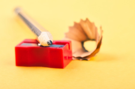 Back To school Concept, pencil with it shavings and sharpener over yellow background