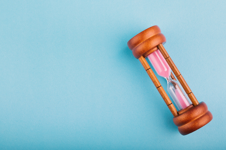 hourglass on blue background for direction or running out of time concept, copy space for text