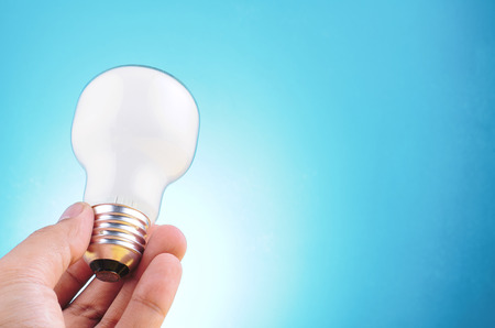 hand holding light bulb over beautiful reverberation gradient background for creative ideas concept