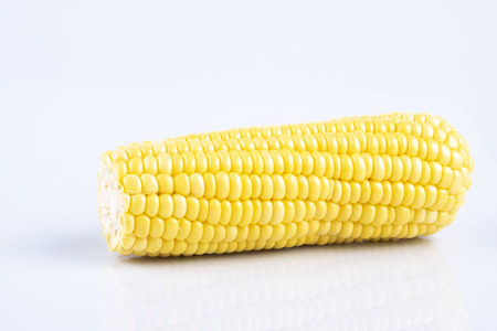 fresh raw sweet corn on the cob kernels over white backgroundの写真素材