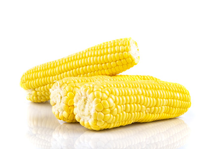 fresh raw sweet corn on the cob kernels over white backgroundの写真素材