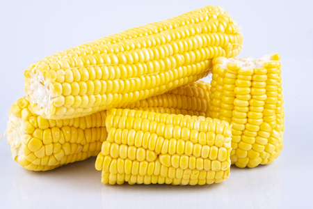 fresh raw sweet corn on the cob kernels over white backgroundの写真素材