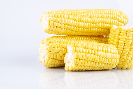 fresh raw sweet corn on the cob kernels over white backgroundの写真素材