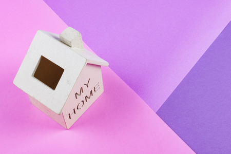 mortgage and new home concept, miniature wooden house on desk over colorful backgroundの写真素材