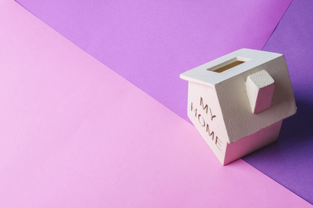 mortgage and new home concept, miniature wooden house on desk over colorful backgroundの写真素材