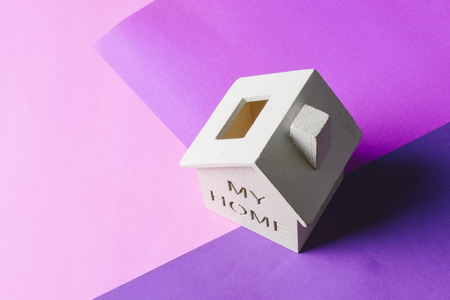 mortgage and new home concept, miniature wooden house on desk over colorful backgroundの写真素材