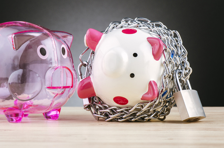 financial crisis or economic depression concept, piggy bank surrounded by chains  and padlock on wooden deskの写真素材
