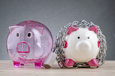 financial crisis or economic depression concept, piggy bank surrounded by chains  and padlock on wooden deskの写真素材