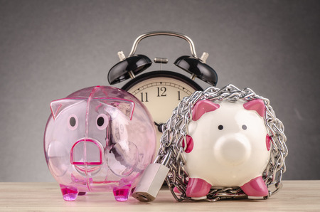 financial crisis or economic depression concept, piggy bank surrounded by chains  and padlock on wooden deskの写真素材