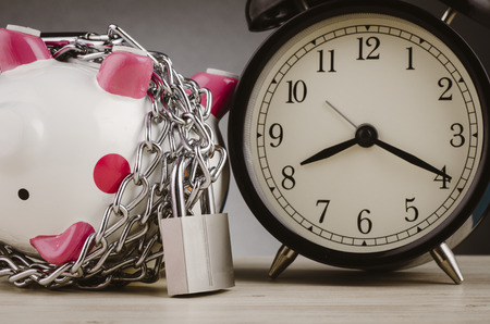 financial crisis or economic depression concept, piggy bank surrounded by chains  and padlock on wooden deskの写真素材