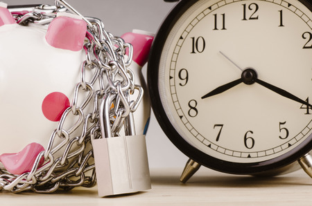 financial crisis or economic depression concept, piggy bank surrounded by chains  and padlock on wooden deskの写真素材