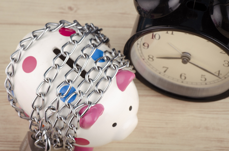financial crisis or economic depression concept, piggy bank surrounded by chains  and padlock on wooden deskの写真素材