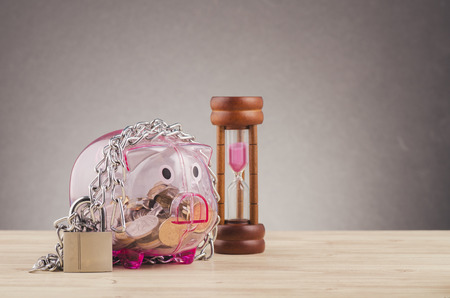 financial crisis or economic depression concept, piggy bank surrounded by chains  and padlock on wooden deskの写真素材