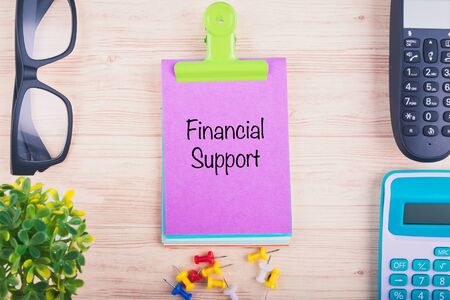 Business concept background, workplace with word FINANCIAL SUPPORT written on notepadの写真素材