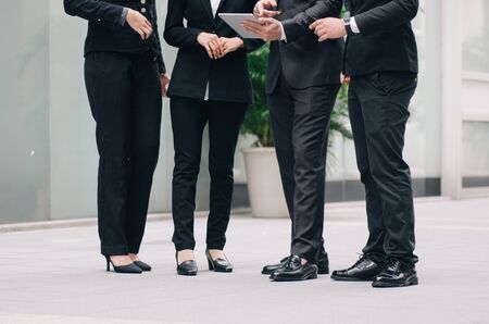 unidentified image group of young executive people in formalwear holding tablet and discussing somethingの写真素材