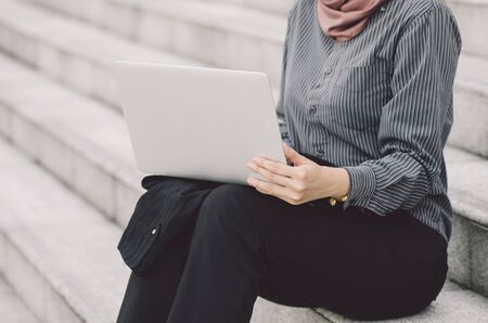 unidentified young executive sitting on stars and work with her laptopの写真素材