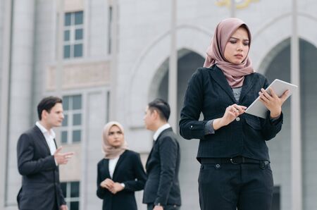unhappy expression, young businesswoman standing and holding her tabletの写真素材