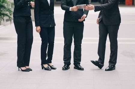 unidentified image group of young executive people in formalwear holding tablet and discussing somethingの写真素材