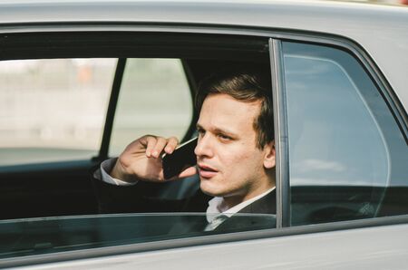 Portrait of young businessman talking to Someone on his Mobile Phone with Happy Facial Expression.の写真素材