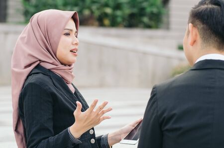 Group of young executive people in formalwear discussing something and gesturing