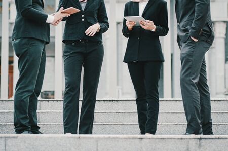 cropped unidentifed business people with suit standing on stairs and discussing somethingの写真素材