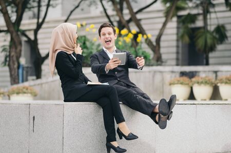 happy smiling and cheerful face of  businesspeople in formalwear sitting outside their officeの写真素材