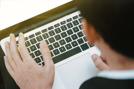 Cropped image of a young man working on his laptopの写真素材
