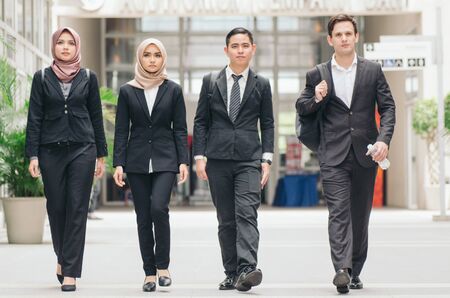 young and confident business people walking together in a modern office corridorの写真素材