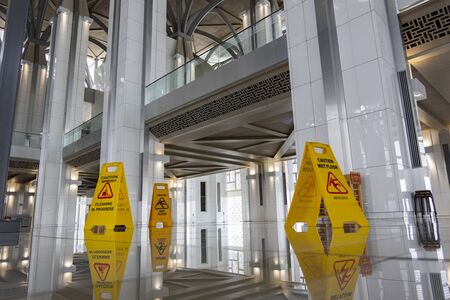 image of yellow sign board showing warning of caution wet floor in the mosqueの写真素材